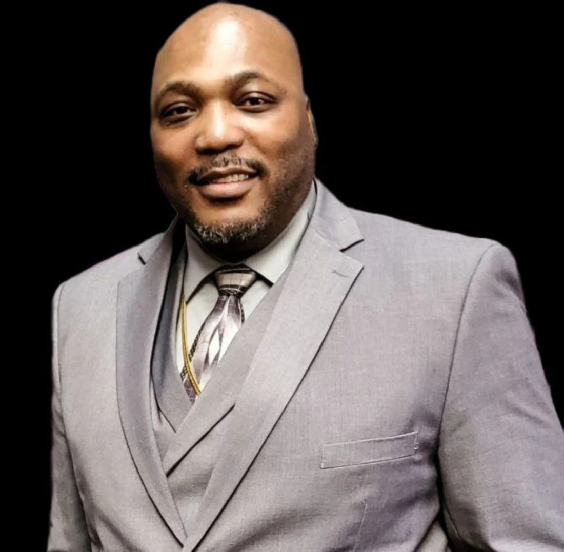 Ruben Broadnax in a gray suit and tie